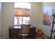 Cozy office with a dark wood desk, rolling chair, and a sun-filled window at 7515 Splashing Rock Dr, Las Vegas, NV 89131