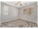 Empty bedroom with wood floors, two windows with blinds, and neutral paint at 781 Drammatico Pl, Henderson, NV 89011