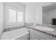 Bright bathroom featuring a soaking tub, window shutters, and granite countertop at 8976 S Park St, Las Vegas, NV 89178