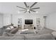 Comfortable living room featuring a large sectional sofa, ceiling fan, and built-in shelving units at 8976 S Park St, Las Vegas, NV 89178