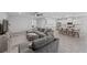Bright open-plan living room with a large gray sectional couch flowing into a modern kitchen and breakfast bar at 8976 S Park St, Las Vegas, NV 89178