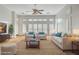 Cozy living room with neutral-toned furniture, large windows, and a ceiling fan at 10025 Netherton Dr, Las Vegas, NV 89134