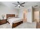 Bright main bedroom featuring neutral walls, carpet, ceiling fan, and ensuite bathroom at 10255 Crimson Currant St, Las Vegas, NV 89143