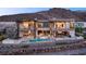 Luxury home featuring an infinity pool, outdoor lounge areas, and lush landscaping for resort-style living at 11 Rockstream Dr, Henderson, NV 89012