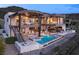 Contemporary home featuring a luxurious backyard with a pool, spa, and fire pit lounge area at 11 Rockstream Dr, Henderson, NV 89012
