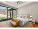 Bright bedroom boasts a king bed, neutral decor, and scenic views of the Nevada landscape through large windows at 11 Rockstream Dr, Henderson, NV 89012