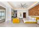Bright bedroom with a decorative wall, a yellow sofa, fireplace and a large ceiling fan at 11 Rockstream Dr, Henderson, NV 89012