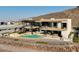 Modern two-story home featuring a pool, spa, outdoor seating, and hillside views at 11 Rockstream Dr, Henderson, NV 89012