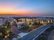 Modern two-story home showcasing expansive windows, sleek lines, and stunning city views at sunset at 11 Rockstream Dr, Henderson, NV 89012