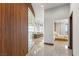 Bright hallway leading to bedroom with a window view, wood wall, and marble floors at 11 Rockstream Dr, Henderson, NV 89012