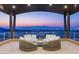 Covered patio lounge area offers stunning views of the city skyline at dusk at 11 Rockstream Dr, Henderson, NV 89012