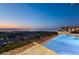 An infinity pool offers stunning city and mountain views at twilight at 11 Rockstream Dr, Henderson, NV 89012