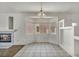 Bright dining area features a bay window, chandelier, tile flooring, and a cozy fireplace at 1562 Pimlico Hills St, Henderson, NV 89014