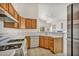 Functional kitchen with white appliances, wood cabinets, and tile countertops at 1562 Pimlico Hills St, Henderson, NV 89014