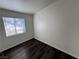 A vacant room featuring dark laminate flooring and white walls with a window at 1920 Hodgenville St # 106, Las Vegas, NV 89106