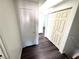 A hallway featuring dark laminate flooring and a set of closet doors at 1920 Hodgenville St # 106, Las Vegas, NV 89106