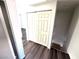 A hallway featuring dark laminate flooring and a set of closet doors with stairs at 1920 Hodgenville St # 106, Las Vegas, NV 89106