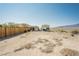 Fenced-in backyard and adjacent buildings in a rural location at 1920 Silver St, Pahrump, NV 89048