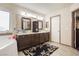 Bathroom with a tub, shower, and sinks, dark wood vanities, and decorative mirrors at 1920 Silver St, Pahrump, NV 89048