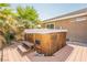 Inviting wooden hot tub with built-in seating on a patio with palm trees at 1920 Silver St, Pahrump, NV 89048