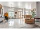 Bright living room with tile floors, ceiling fan, and natural light from large windows and glass patio doors at 1920 Silver St, Pahrump, NV 89048