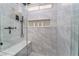 Modern walk-in shower featuring marble-like tile, a built-in niche, bench, and black hardware at 2009 Emerald Green Ave, Las Vegas, NV 89106