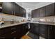 A galley kitchen featuring dark cabinets, granite countertops, and tile flooring at 214 Earl St, Las Vegas, NV 89101