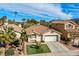 Beautiful home with a spacious driveway, front lawn, and mature palm trees at 254 Camelback Ridge Ave, Henderson, NV 89012