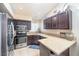 Well-lit kitchen features stainless steel appliances, dark wood cabinets, granite countertops, and a breakfast bar at 254 Camelback Ridge Ave, Henderson, NV 89012