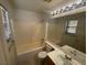 A well-lit bathroom features tiled walls, a vanity, toilet, tub, and shower combo at 2637 Heathrow St, Las Vegas, NV 89135