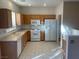 Well-lit kitchen with oak cabinets, white appliances, and tile floors at 2637 Heathrow St, Las Vegas, NV 89135
