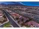 An aerial view shows houses with desert landscaping, tile roofs, and neighborhood streets at dusk at 2747 White Sage Dr, Henderson, NV 89052