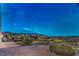 Night falls on this desert landscaped backyard with a fence offering wide open views of the city at 2747 White Sage Dr, Henderson, NV 89052
