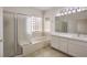 Bathroom features dual sinks, soaking tub, and glass-enclosed shower at 2747 White Sage Dr, Henderson, NV 89052