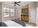 Staged bedroom with hardwood-style floors, ceiling fan, and a wet bar at 2747 White Sage Dr, Henderson, NV 89052