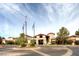 Welcoming entrance to a clubhouse with flags, a roundabout, and well-kept landscaping for an inviting curb appeal at 2747 White Sage Dr, Henderson, NV 89052