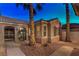 Inviting entrance featuring desert landscaping, stucco walls, a tiled roof, and a charming arched doorway at 2747 White Sage Dr, Henderson, NV 89052