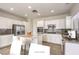 Well-lit kitchen with white cabinets, stainless steel appliances, and island seating at 2747 White Sage Dr, Henderson, NV 89052