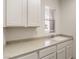 Functional laundry room with sink, cabinets, and natural light from window at 2747 White Sage Dr, Henderson, NV 89052