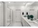 Bright bathroom featuring double sinks, white cabinetry, and a sleek glass-enclosed shower at 283 Fossil Falls St, Henderson, NV 89015