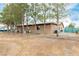 Spacious backyard featuring a partially fenced lot, mature trees, and lots of space at 3051 S Rainbow Ave, Pahrump, NV 89048