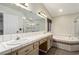 Bathroom features a dual sink vanity, large mirror, and a separate tub and tiled glass door shower at 3051 S Rainbow Ave, Pahrump, NV 89048