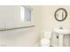 Cozy bathroom featuring a pedestal sink, toilet and grab bar at 3051 S Rainbow Ave, Pahrump, NV 89048