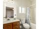 This bathroom features a wooden vanity with an oval mirror and a shower-tub combo at 3051 S Rainbow Ave, Pahrump, NV 89048