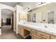 Large bathroom vanity with dual sinks, tile countertop, cabinets, and a walk-in closet in the background at 3051 S Rainbow Ave, Pahrump, NV 89048