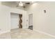 Empty room featuring tile flooring, a ceiling fan and light, and freshly painted neutral walls at 3051 S Rainbow Ave, Pahrump, NV 89048