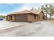 Side view of a tan home showing a well maintained garage and desert landscaping at 3051 S Rainbow Ave, Pahrump, NV 89048