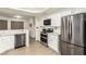 Bright kitchen featuring stainless steel appliances, white cabinetry, and updated countertops at 3051 S Rainbow Ave, Pahrump, NV 89048