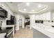 Bright kitchen featuring white cabinets, hardwood floors, neutral walls, stone countertops, and modern appliances at 3051 S Rainbow Ave, Pahrump, NV 89048