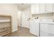 Bright laundry room with ample storage, featuring a modern washer and dryer at 3051 S Rainbow Ave, Pahrump, NV 89048